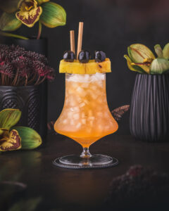 Orange Tiki Cocktail with cherry and pineapple garnish. Don Beachcomber Tiki Punch.