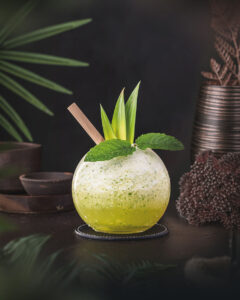 Missionarys Downfall - Green Tiki Cocktail looking like a smoothie. Garnished with Mint and pineapple.