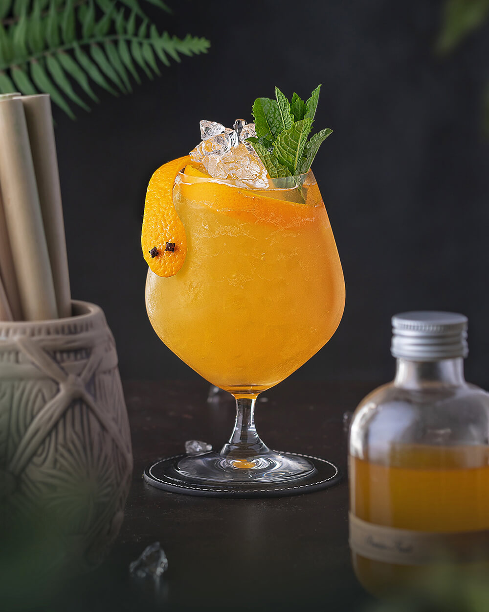 Tiki Cocktail mit Schlange. Gelb mit Orangensaft und Minze