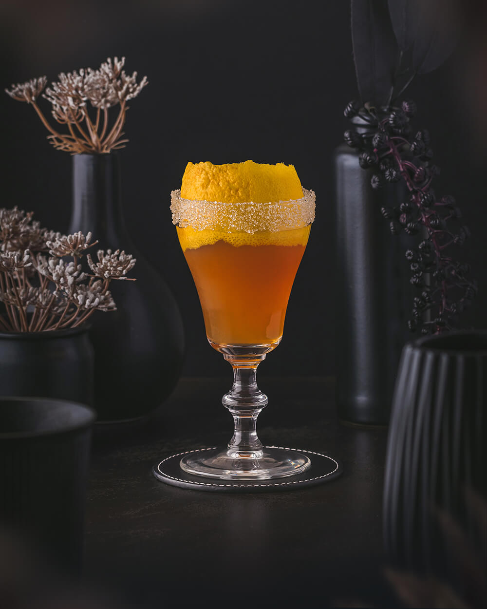 Brandy Crusta - Classic orange brown cocktail made with cognac, dry curaçao, maraschino, lemon juice, sugar cane syrup and angostura bitters, with a sugar rim and a large lemon zest as garnish.
