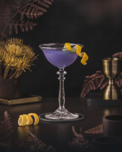 Water Lily - Blue violet Cocktail with lemon twist garnish. Blooming Cocktail with Floral notes.