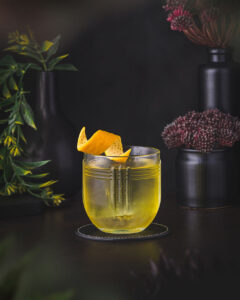White Negroni - Yellow Gin based cocktail with grapefruit garnish served in a tumbler
