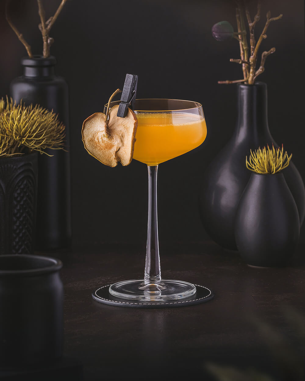 Applejack Rabbit - Yellow orange cocktail with apple brandy, maple syrup and orange juice. Garnished with a dried apple slice.