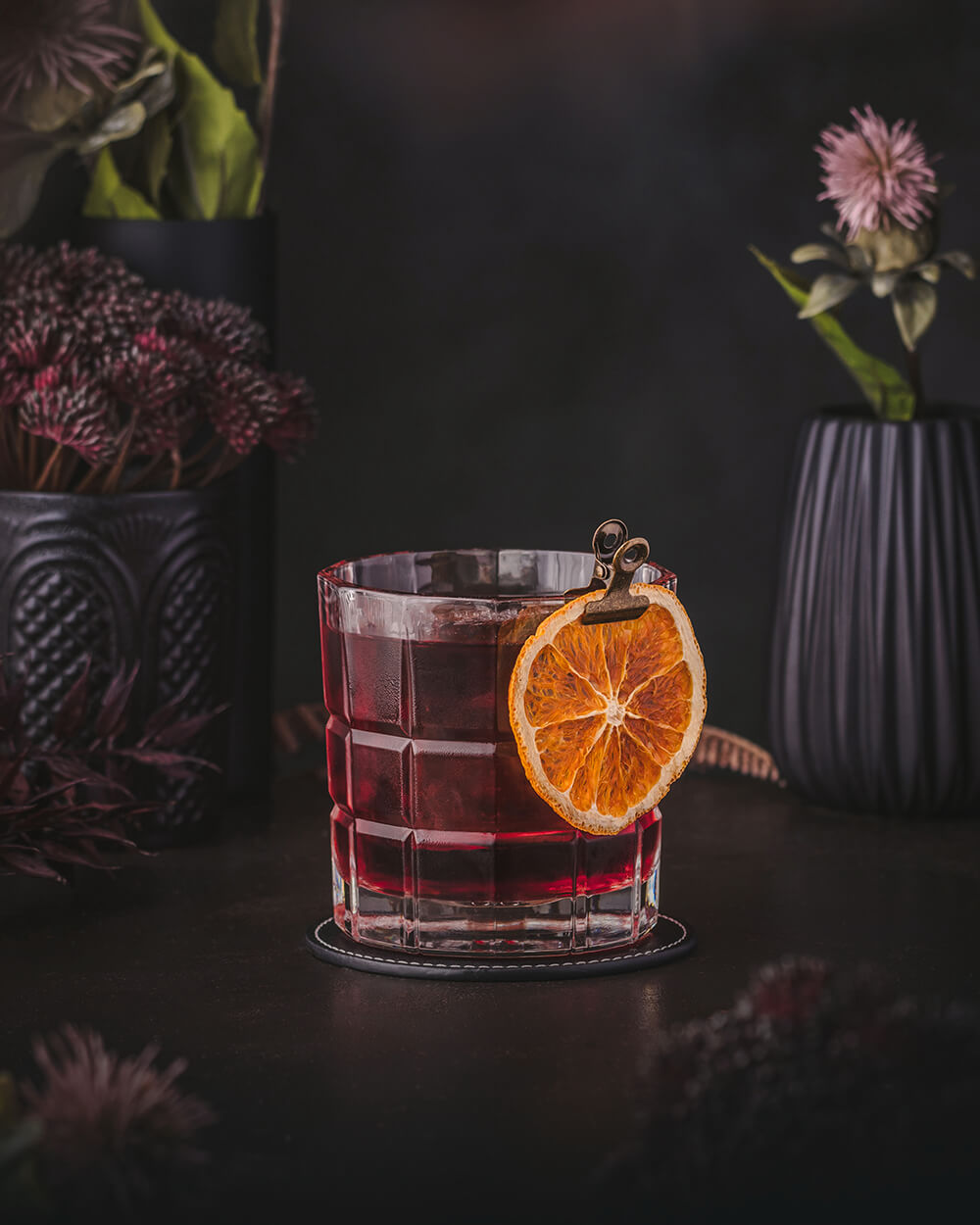 Kingston Negroni - Deep red Negroni twist made with Jamaican rum. garnished with an orange wheel.