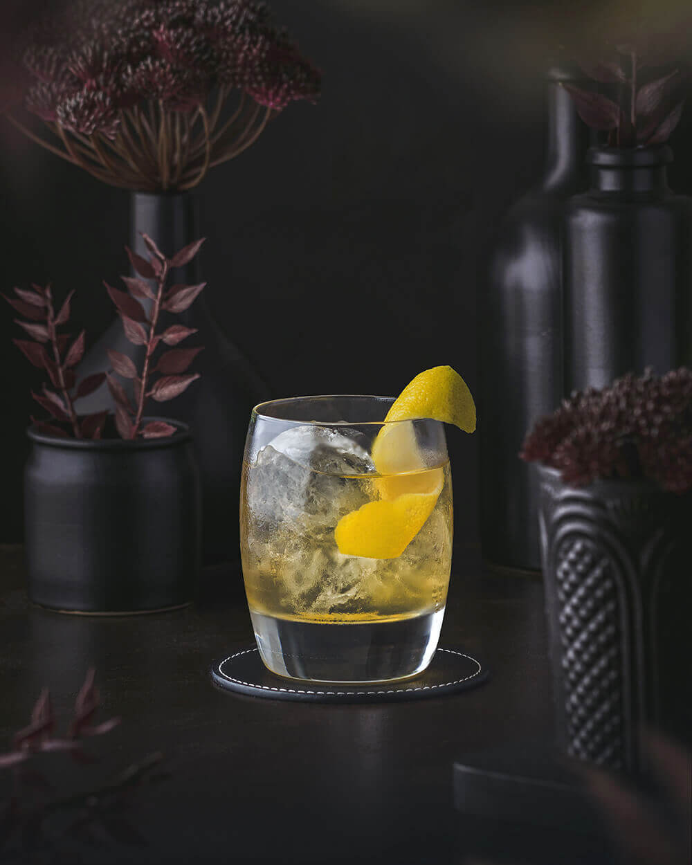 Padovani Cocktail - Scotch with Elderflower liqueur. Yellow orange drink served on the rocks. garnished with a lemon twist.