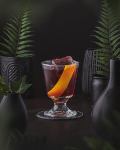 Vieux Carré - A classic cocktail from New Orleans made with rye whiskey and cognac. deep red drink with lemon garnish.
