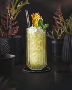 Chartreuse Swizzle - Green Cocktail with herbal chartreuse liqueur and pineapple juice. With mint and pineapple garnish.