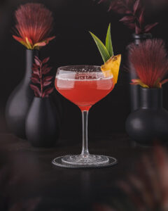 Mary Pickford Cocktail - Red Cocktail served in a coupe glass garnished with pineapple. Made with white rum, grenadine, maraschino and pineapple.